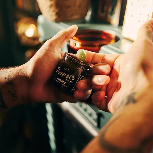 Pomade med shine finish Åben pomade fra Pomp & Co. med indhold på finger.