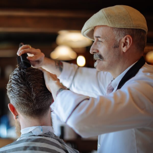 Barber klipper klipper ung mand Irsk barber fra Sam's Barber klipper en af sine kunder i salonen.