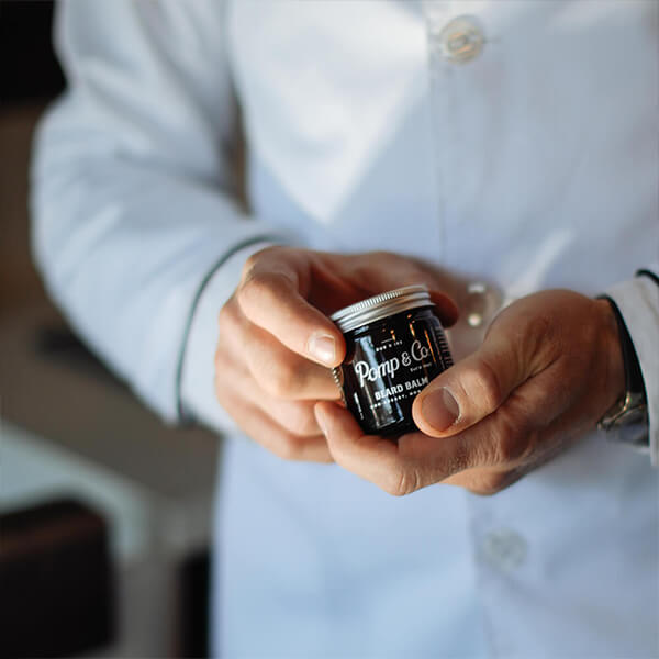 Barber med beard balm Irsk barber holder en Pomp & Co. skægbalm.