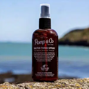 Saltvandsspray fra Pomp & Co. står udendørs ved hav.