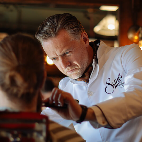 Sam Donnelly barberer mand Koncentration i Sam's Barber i Dublin når kunderne bliver barberet.